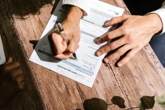 Hồ sơ vay tín chấp trên bàn gỗ với máy tính và giấy tờ — minh họa so sánh lãi suất FE Credit và Home Credit