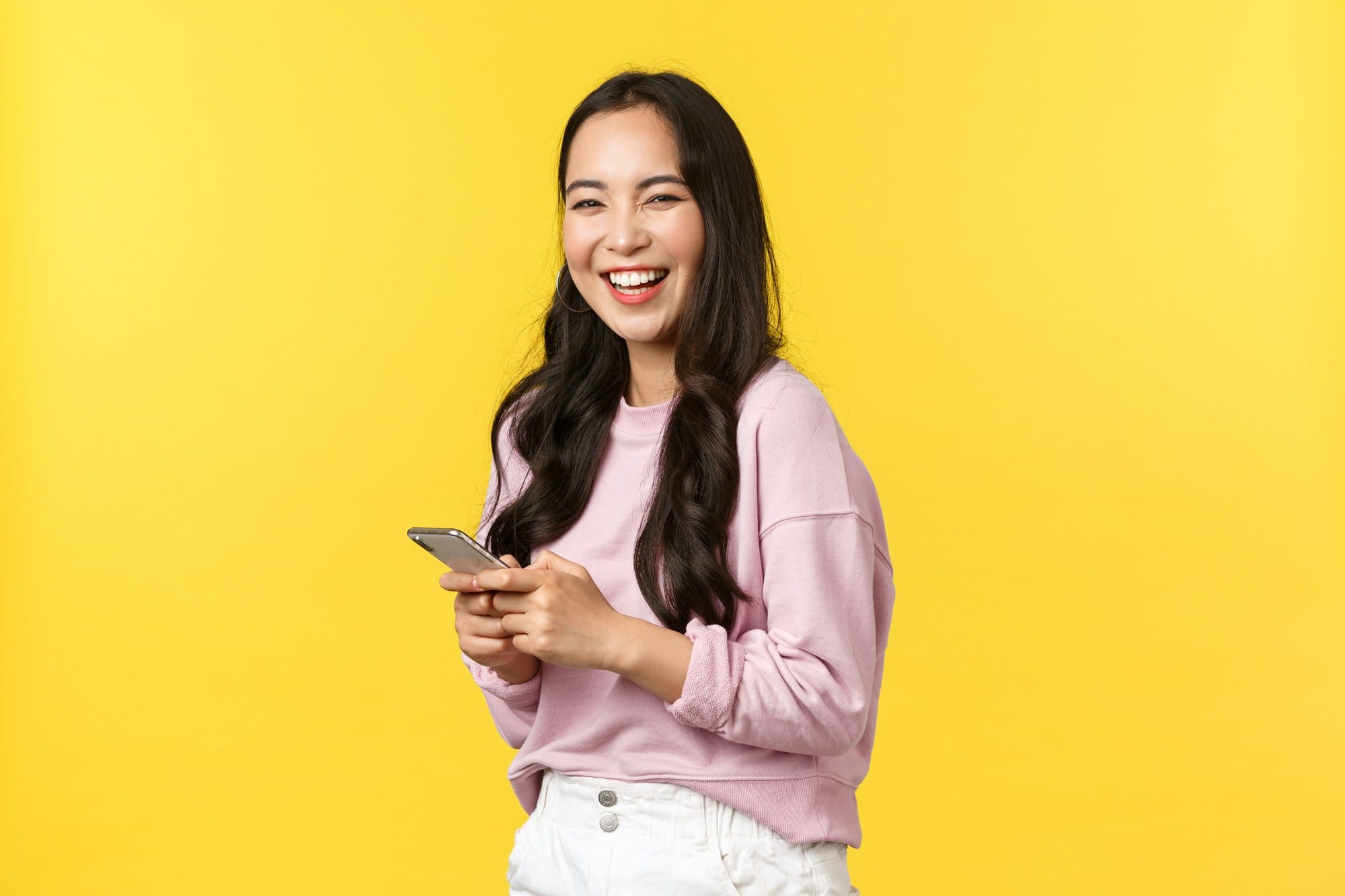 Người phụ nữ cười vui xem điện thoại sau khi đăng ký vay online