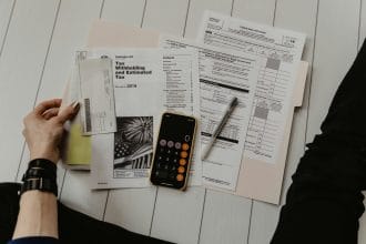 Máy tính và bảng kế hoạch tài chính cá nhân, công cụ tính tỷ lệ nợ trên thu nhập DTI. (Ảnh: Unsplash).